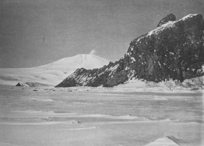 A photograph of Mt. Erebus, with a dark cliff before it.