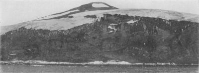 A photograph of a cliff face ending at the sea.