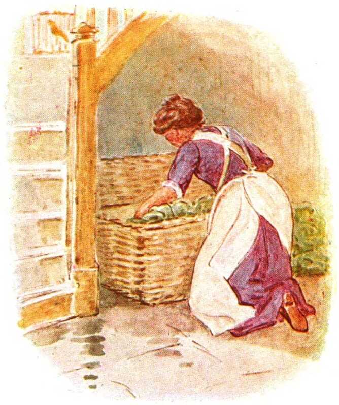 The lady kneels downs to open the hamper and inspect the contents.