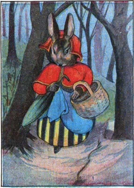 Mrs. Rabbit walks through the wood with her basket and umbrella. She’s wearing a red scarf, red coat, and a yellow and black striped skirt.