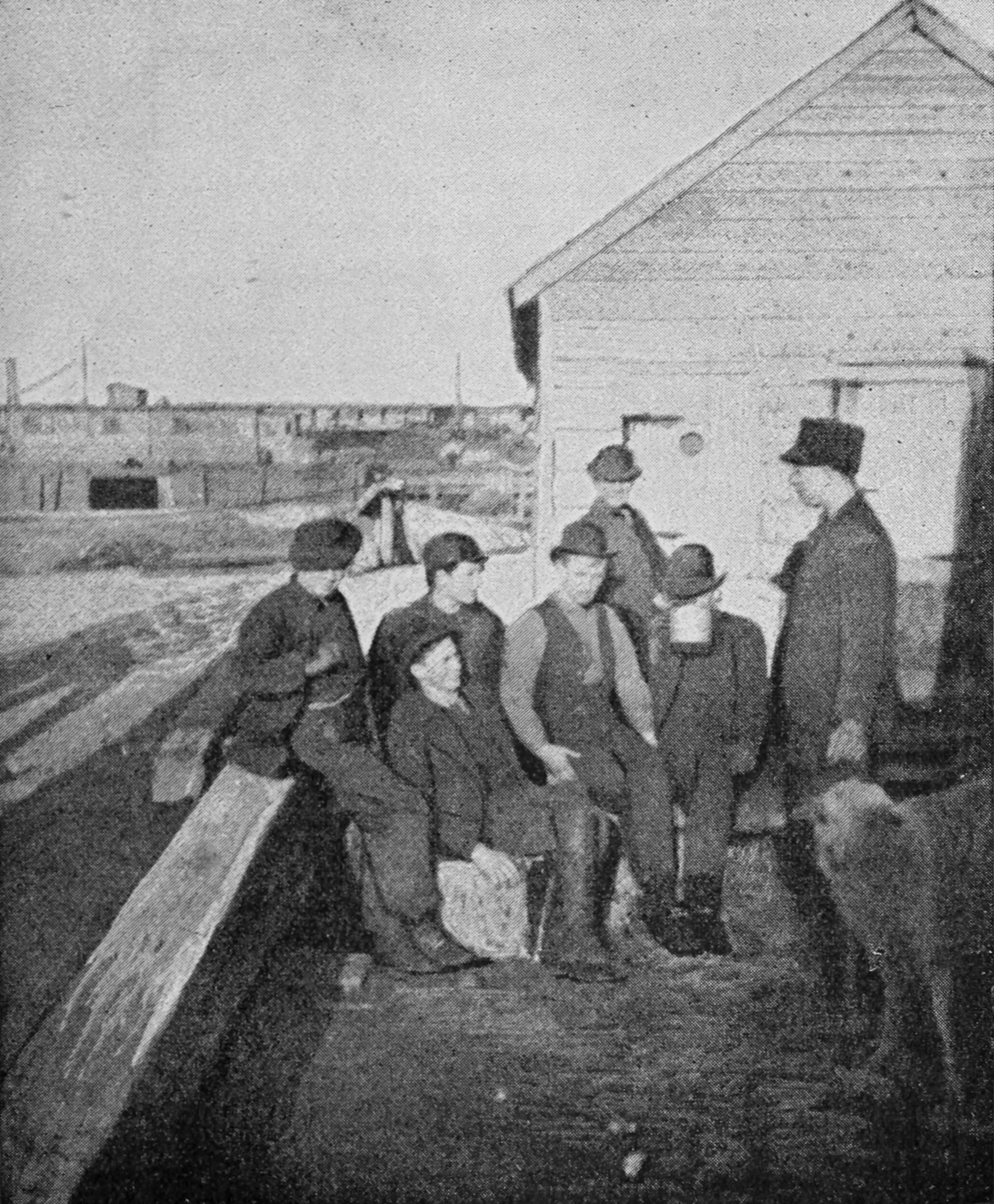 A group of men is gathered outdoors, along with a sheep.
