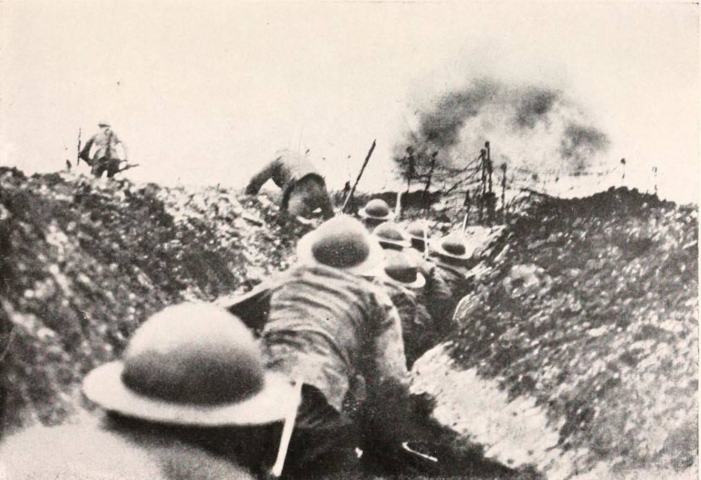 Soldiers with helmets file along a trench, with a few climbing out.